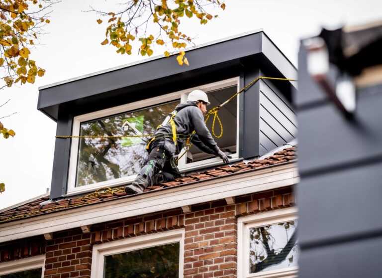 Monteur tijdens het plaatsen van een dubbel dakkapel voor en achter